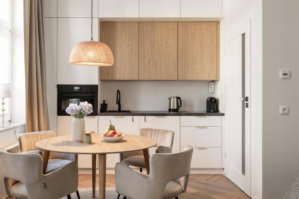 - une cuisine avec une table et un bol de fruits dans l'établissement Sanhaus Apartments - Apartamenty Koral z parkingiem - 200 m od plaży, à Sopot