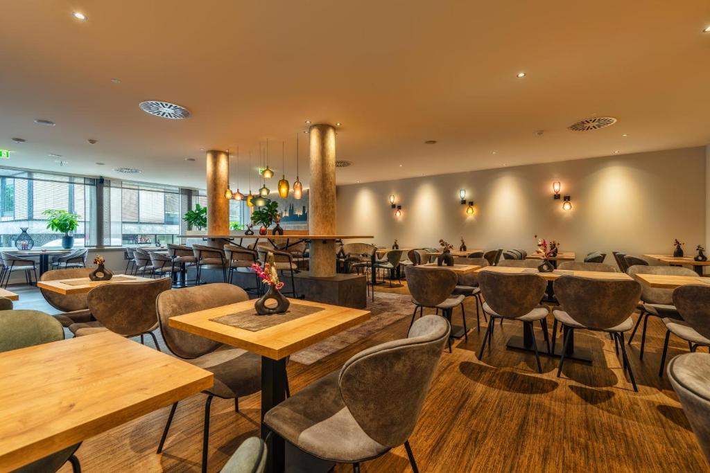 a restaurant with wooden tables and chairs at CityClass Hotel am Dom in Cologne