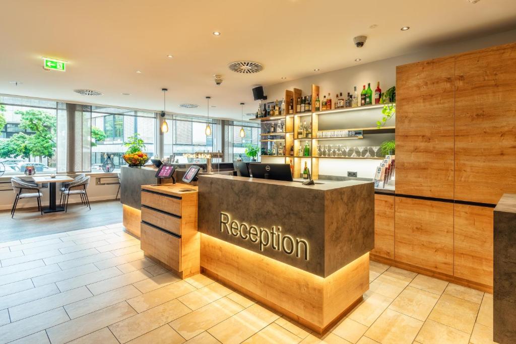 a restaurant with a reception counter and tables at CityClass Hotel am Dom in Cologne