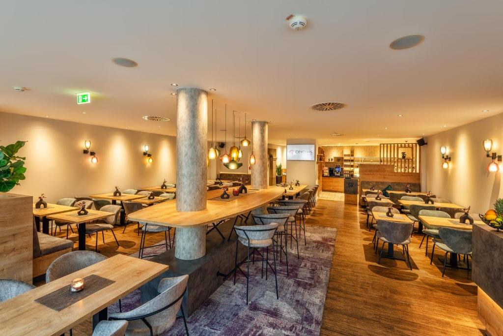 a restaurant with tables and chairs in a room at CityClass Hotel am Dom in Cologne