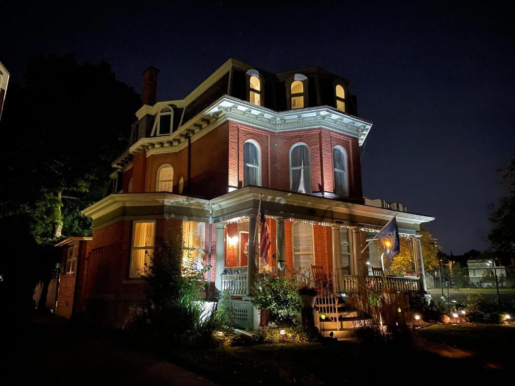 une grande maison éclairée la nuit dans l'établissement Oscar's Inn, à Buffalo
