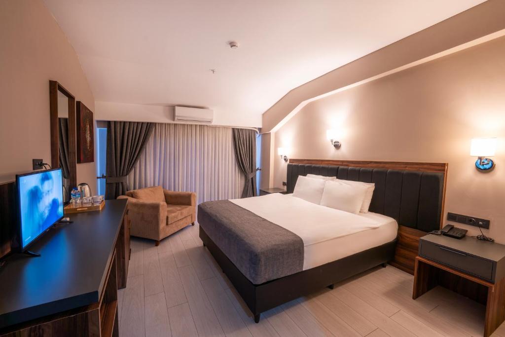ein Hotelzimmer mit einem Bett und einem Flachbild-TV in der Unterkunft Formercity Termal Hotel in Eskisehir