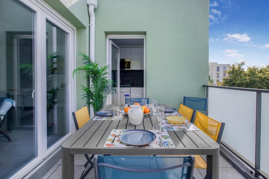 a table on a balcony with a table and chairs at Nouvelle Ère - Appt à moins d’un km de la plage in Le Lavandou