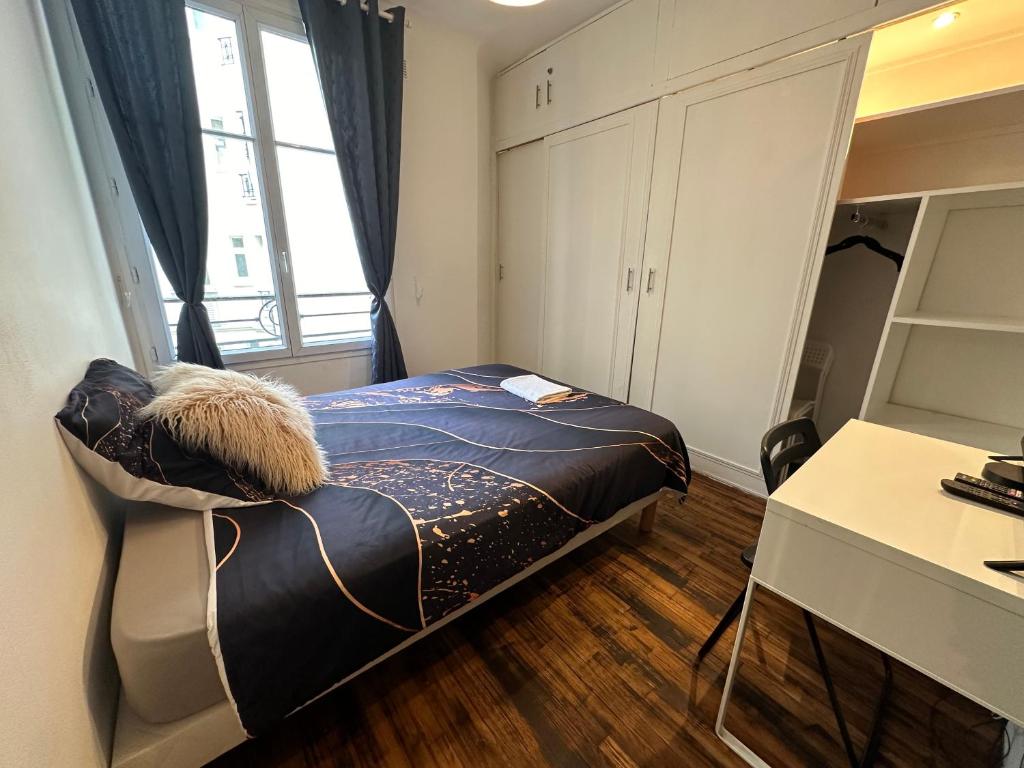 a bedroom with a bed and a desk and a window at Spacieuses Flats Paris Porte de Versailles in Paris