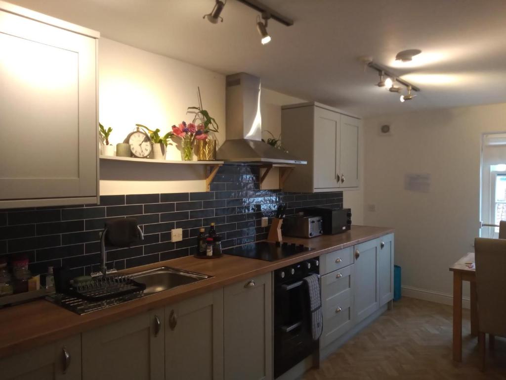 a kitchen with a sink and a stove at The Eaves, Glastonbury High Street in Glastonbury
