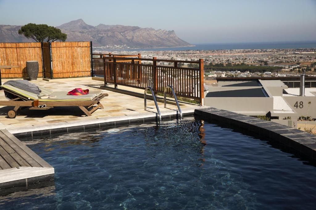 a swimming pool with a bed on a deck at 43 On Sandstone in Somerset West
