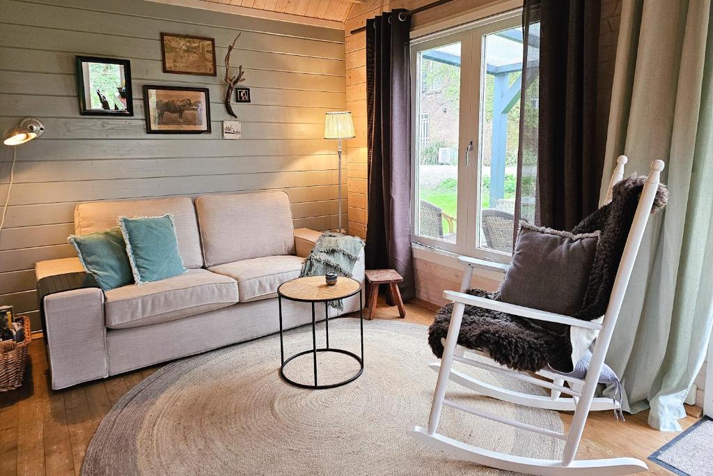 ein Wohnzimmer mit einem Sofa und einem Stuhl in der Unterkunft Vakantiewoning midden in de natuur GR02 Grijpskerke in Grijpskerke