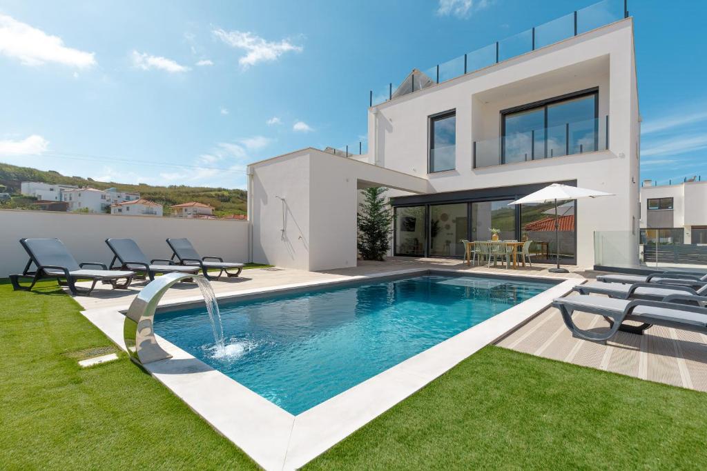 een villa met een zwembad en een huis bij Inspiration Villa in Ribamar