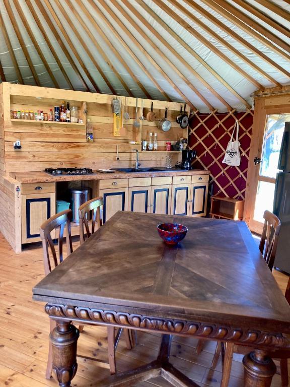 - une cuisine avec une table en bois et un bol dans l'établissement Yourte tout confort éco-responsable, à Saint-Pierre-Eynac
