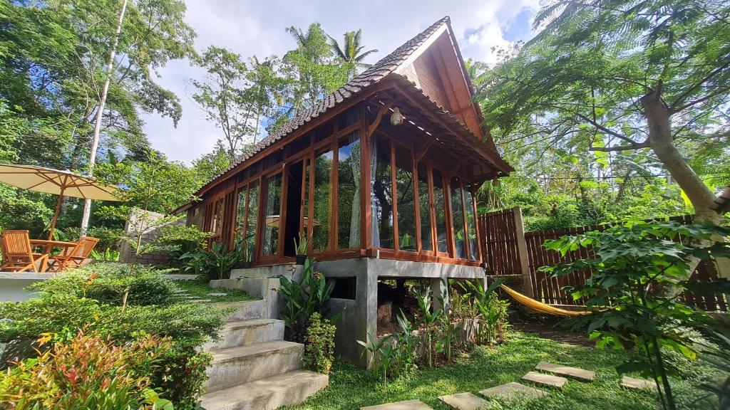 uma pequena casa com escadas que levam até ela em RUMAH KAYU MATARAJA VILLA - TABANAN em Perean