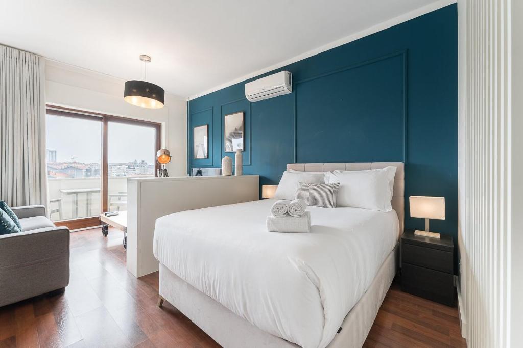 una camera da letto con un letto grande con una parete blu di GuestReady - Almada 516 a Porto