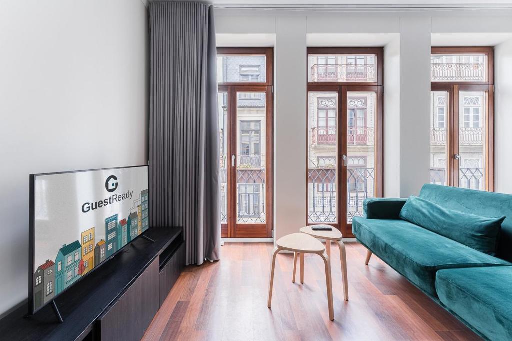 a living room with a couch and a tv at GuestReady - Almada 516 in Porto