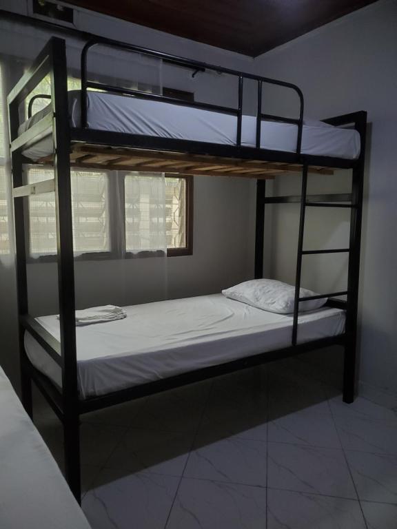 2 literas en una habitación con ventana en The Nest Haven Hostel en Dar es Salaam