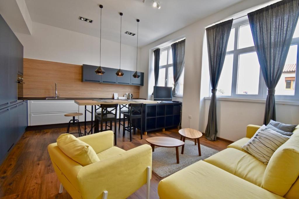 a kitchen and living room with yellow chairs and a table at Modern apartment with 2 bedrooms near Arena in Pula