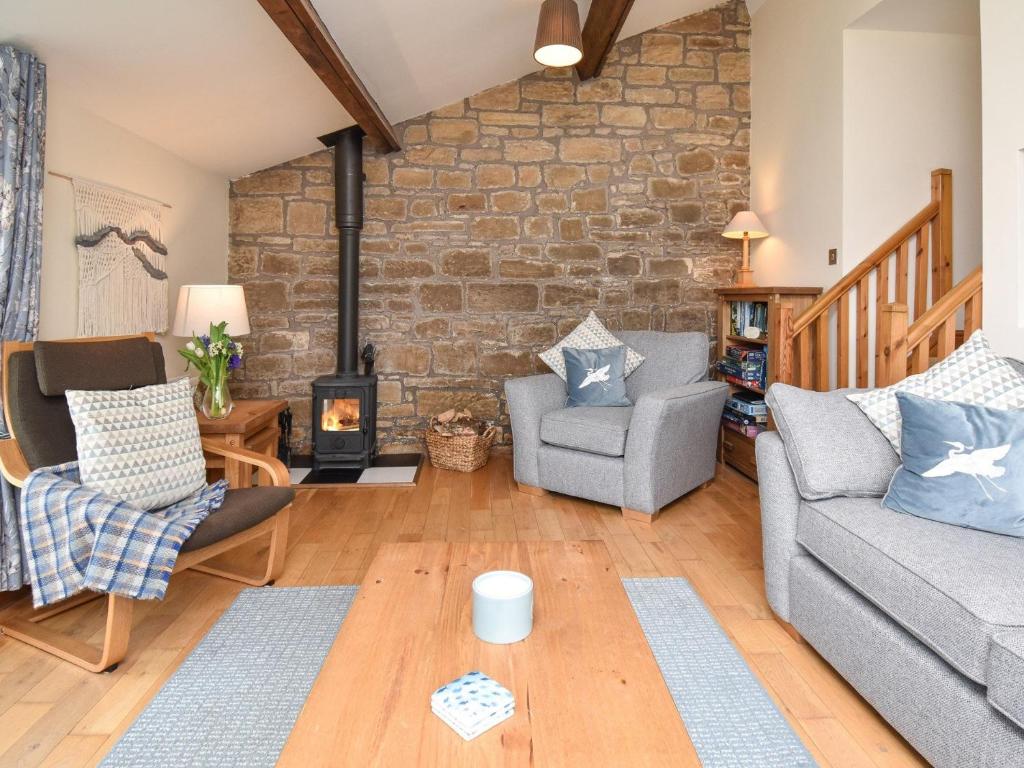 a living room with a brick wall at 2 bed property in Whitton Northumberland 61267 in Rothbury