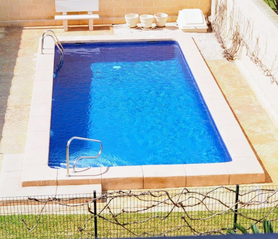 une grande piscine d'eau bleue dans l'établissement Apartamento playa Muchavista de 3 hab y piscina, à El Campello