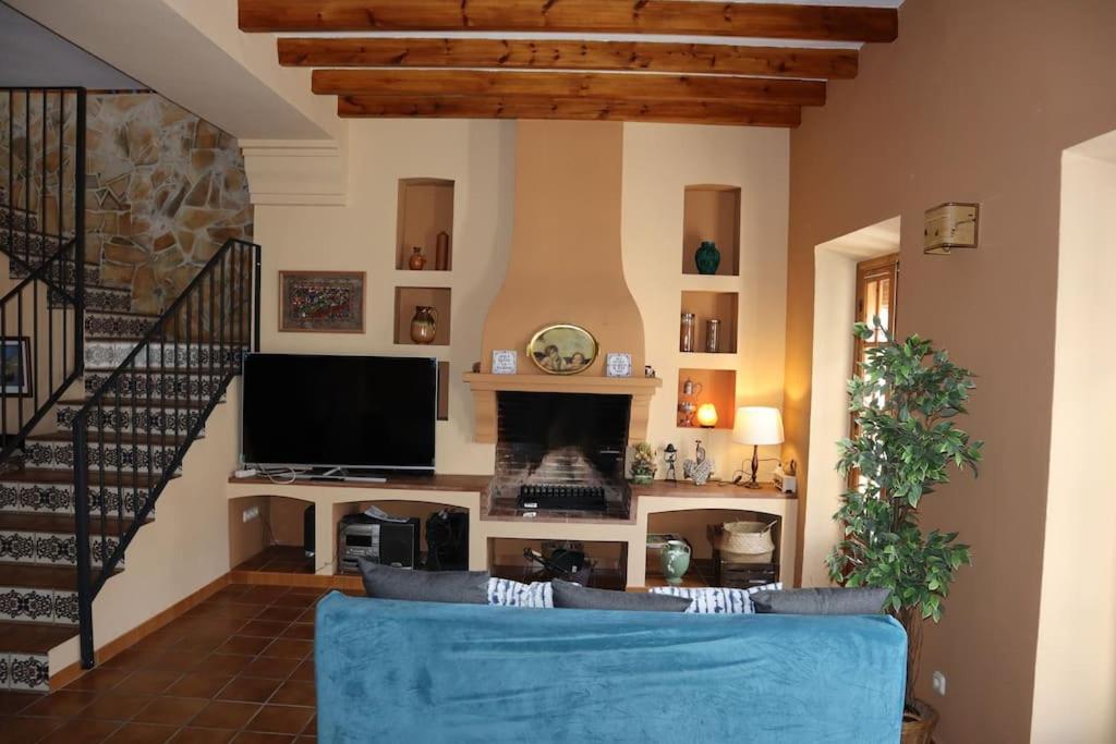 un soggiorno con divano blu e camino di Preciosa casa en Carratraca a Carratraca