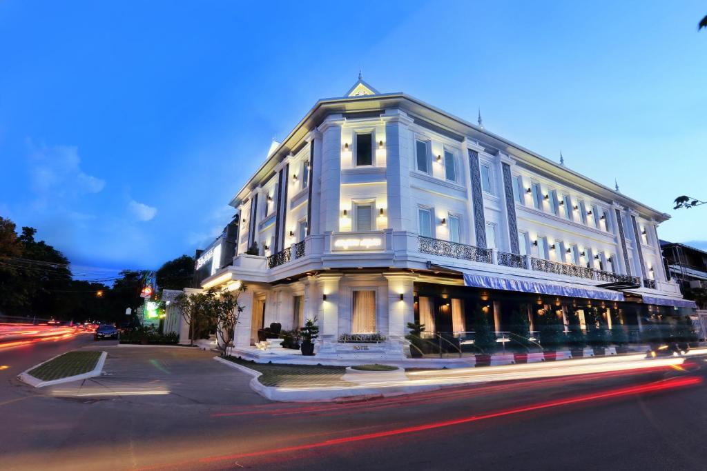 a large white building on the corner of a street at Arunreas Hotel in Phnom Penh