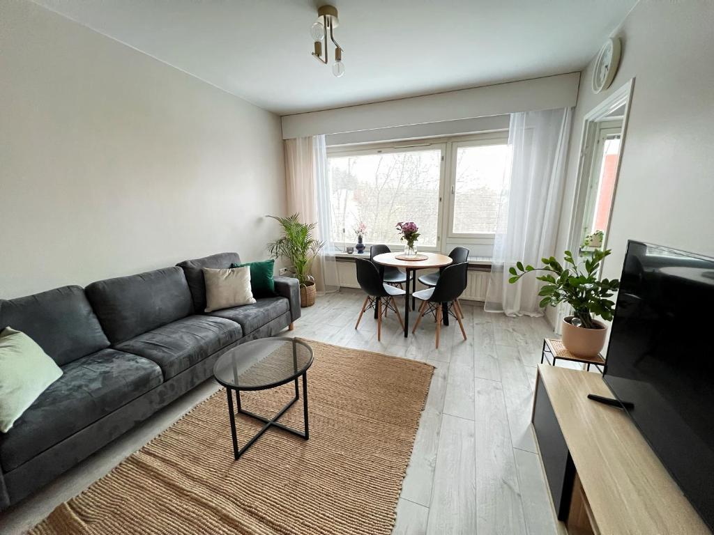 a living room with a couch and a table at Bright & Cozy, Renovated Studio in the Lahti Center in Lahti