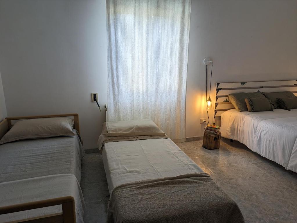 um quarto com 2 camas individuais e uma janela em Palazzo San Pietro Casa Vacanze a 2 passi da Lecce em San Pietro in Lama