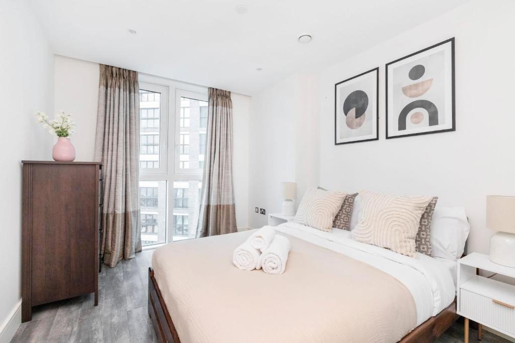 a white bedroom with a large bed and a window at Tower Bridge & Liverpool Street - CityApartmentStay in London