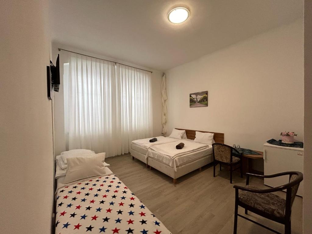 ヘプにあるHotel Monikaのベッドルーム1室(ベッド2台、デスク、テーブル付)