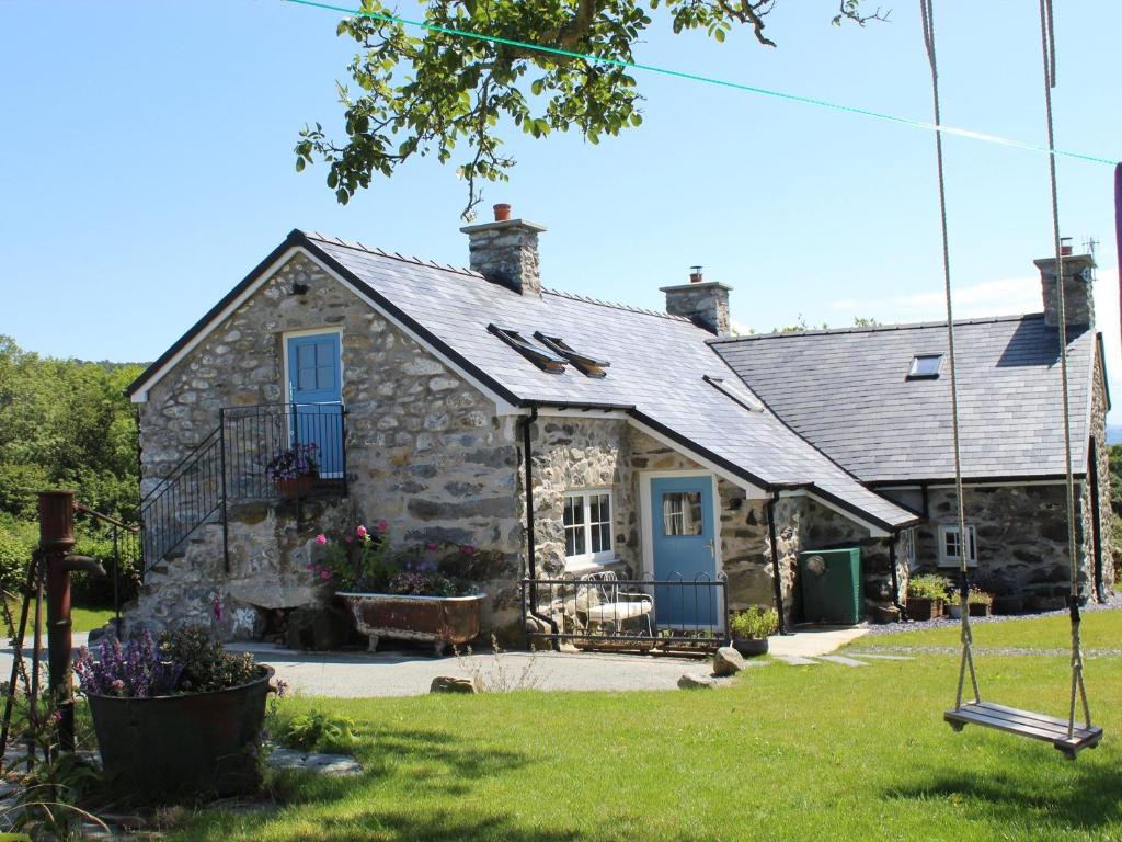 a stone house with blue doors and a yard at 3 Bed in Conwy 80476 in Caerhûn