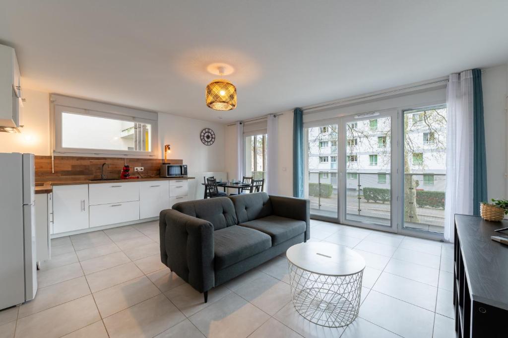 une cuisine et un salon avec un canapé et une table dans l'établissement T3 Grenoble, tout confort, balcon, wifi, à Grenoble