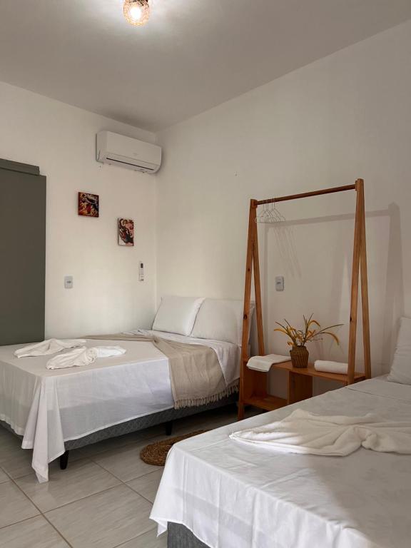 a bedroom with two beds and a mirror at Mara Jeri Pousada in Jericoacoara