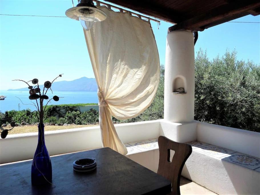 a table and chairs in front of a window at Casa Cavalluccio Marino - terrazza vista mare in Santa Marina Salina
