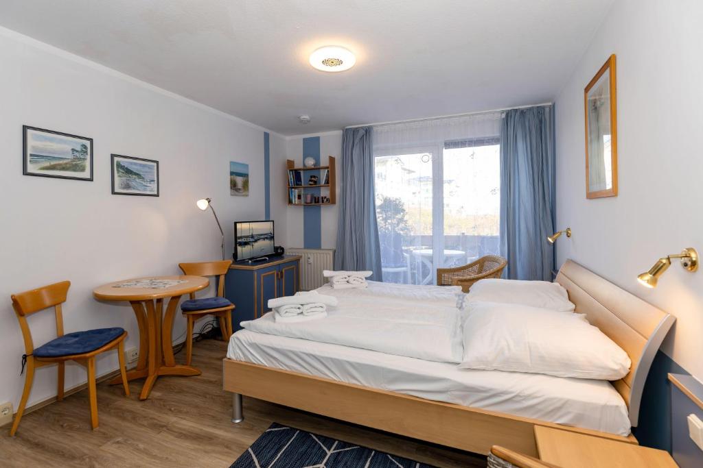 キュールングスボルンにあるYachthafenresidenz-Wohnung-5102-806のベッドルーム1室(ベッド1台、デスク、テーブル付)