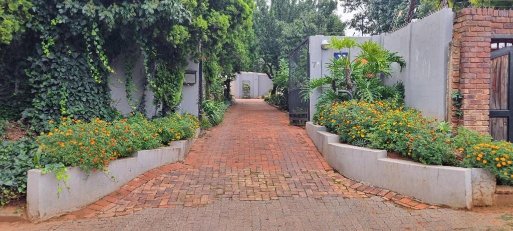a brick pathway with flowers in a garden at 7 on school - Cozy guesthouse 15 min drive from airport and close to major highways in Germiston
