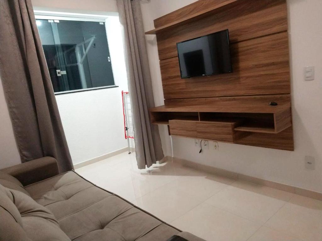 a living room with a couch and a tv on a wall at Apartamento com otima localizacao em Itajai SC in Itajaí