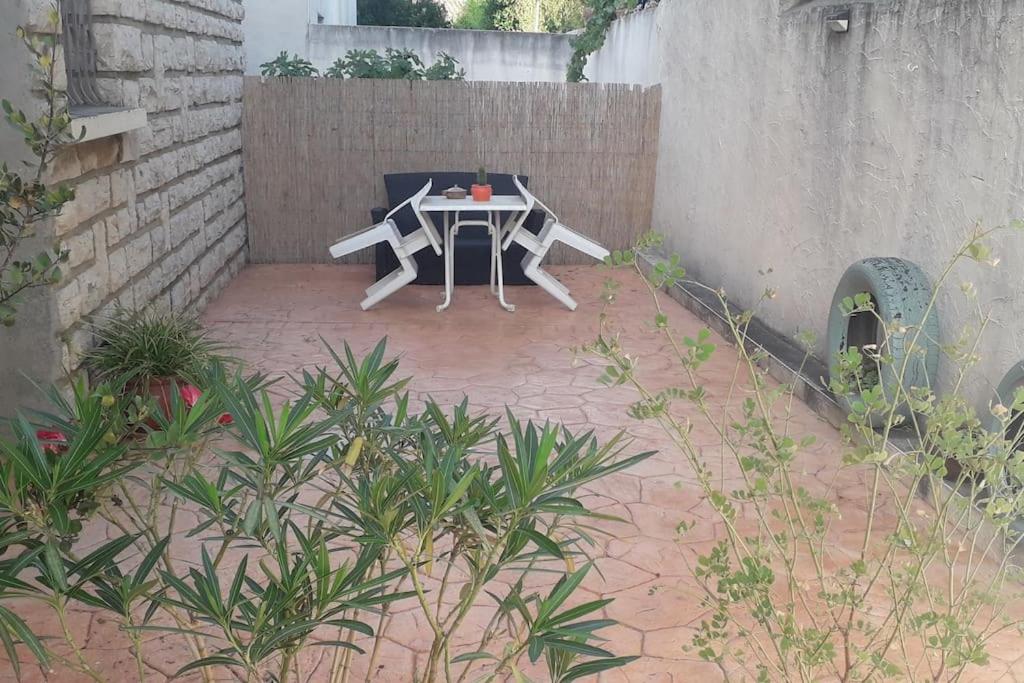 d'une terrasse avec une table dans l'angle d'un bâtiment. dans l'établissement Appartement entre mer et gardiole, à Frontignan