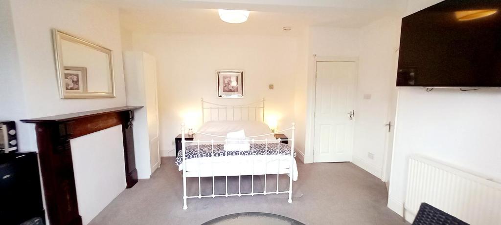 a bedroom with a white bed in a room at Large, Private Ensuite, Bay Window Room. in Sheffield