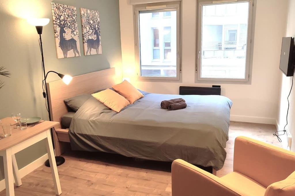 une chambre avec un lit et deux fenêtres dans l'établissement LET'S - Le Jules -Part dieu Wifi, à Villeurbanne