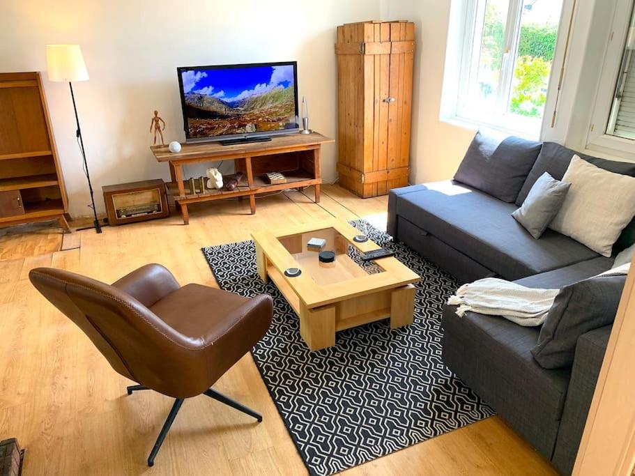 a living room with a couch and a table at Le Marco Yourhosthelper Conciergerie in Lorient