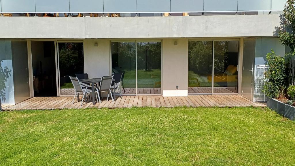 un patio avec une table et des chaises sur une terrasse dans l'établissement Attic quai Paludate, à Bordeaux