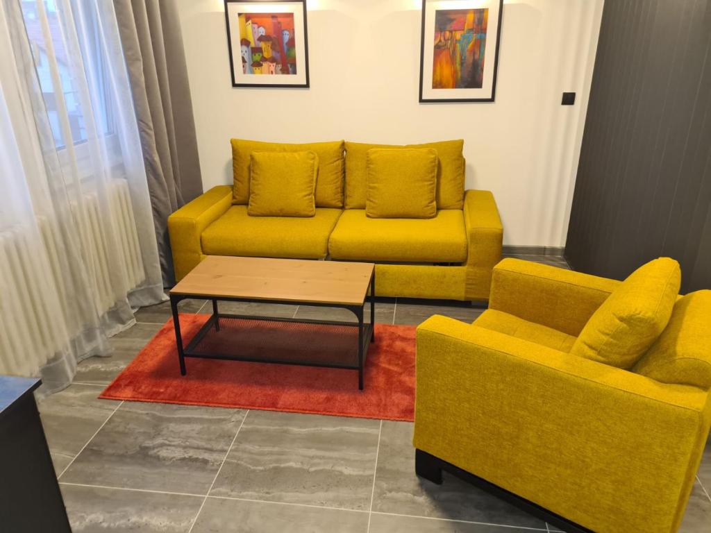 a living room with a yellow couch and a coffee table at Runaway Hill in Bežanija