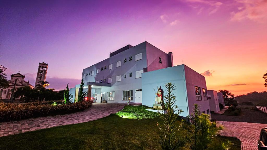 a large white building with a clock tower in the background at Pousada Bom Pastor in Caxias do Sul