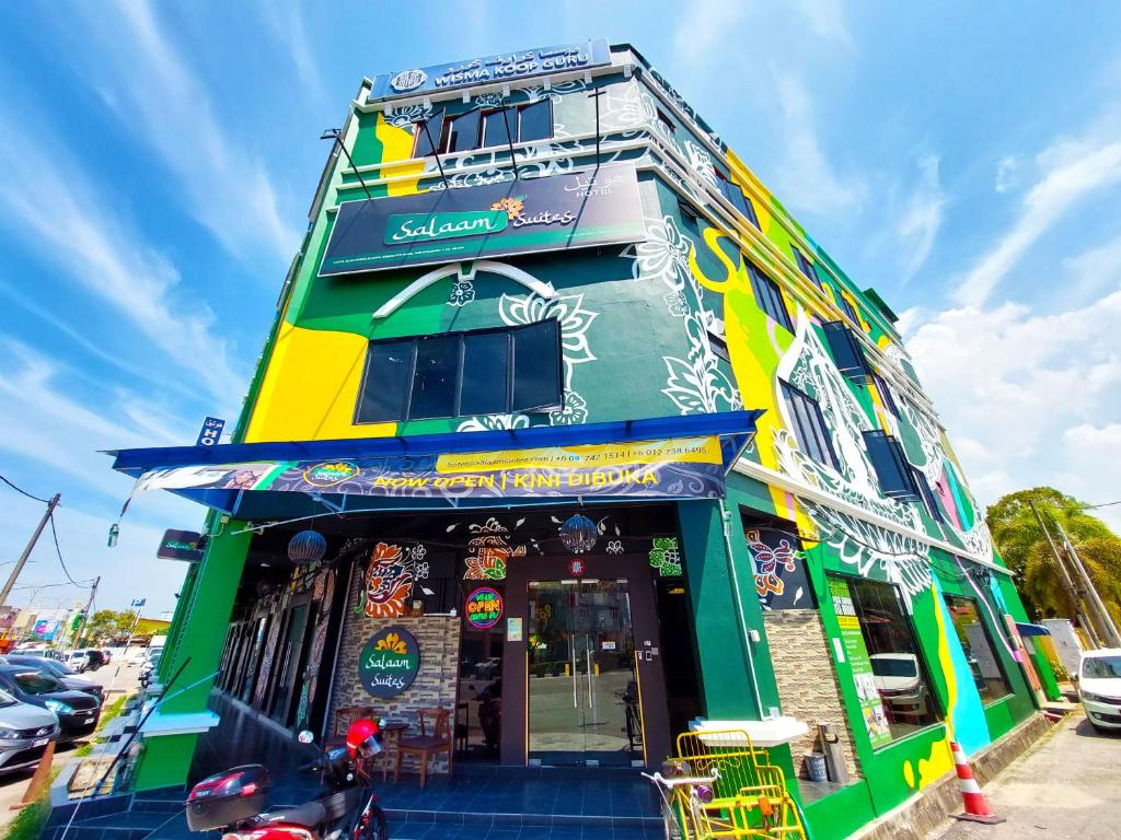 a colorful building with a scooter parked in front of it at Salaam Suites Hotel in Kota Bharu