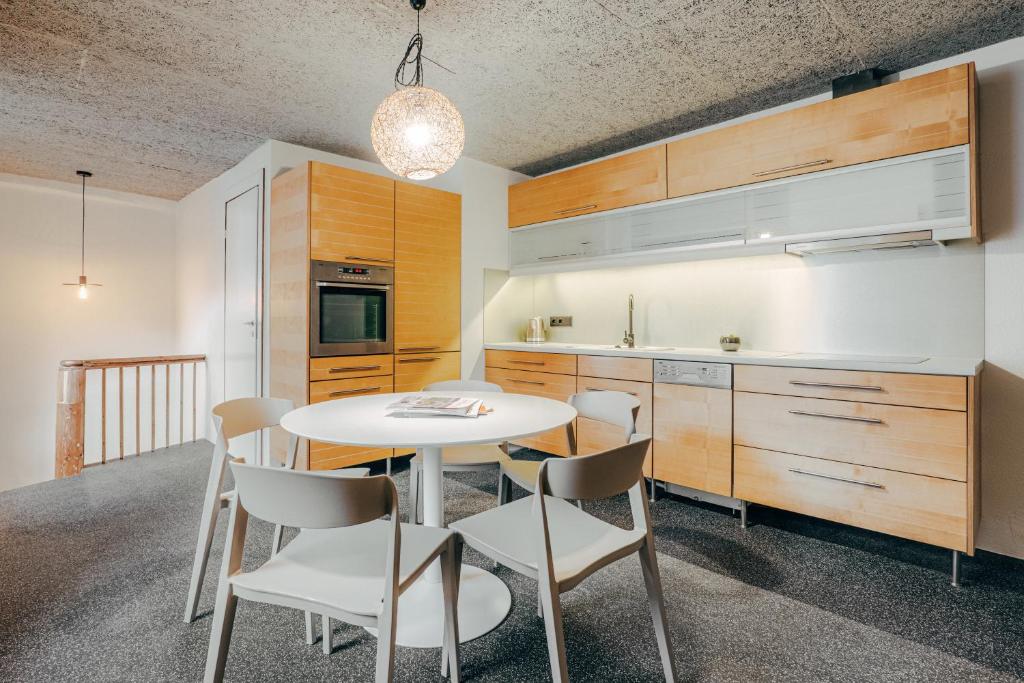 cocina con mesa blanca y sillas en Mighty Squirrel Apartment, en Riga