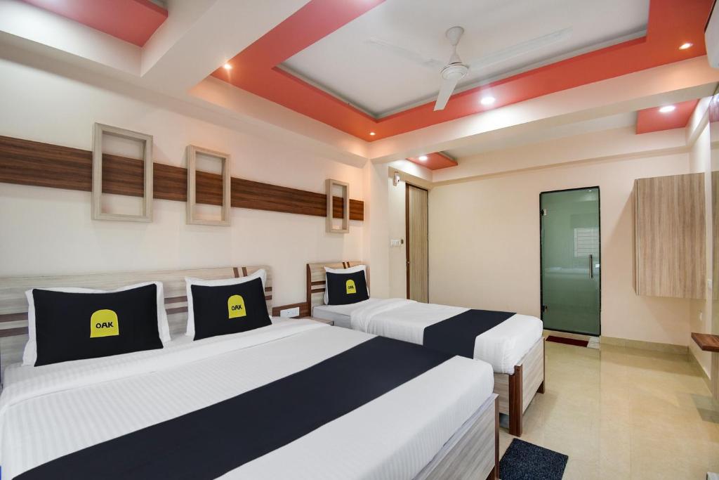 two beds in a room with two windows at OYO Flagship Dream Paradise in Kolkata