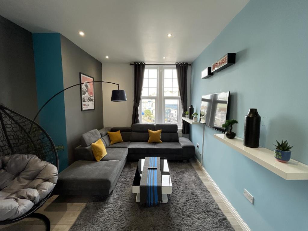 a living room with a couch and a table at Modern Sea View Apartment in Margate