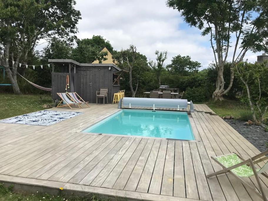 einen Hinterhof mit einem Pool und einer Holzterrasse in der Unterkunft Petite maison bretonne P'ty Penty in Plougastel-Daoulas