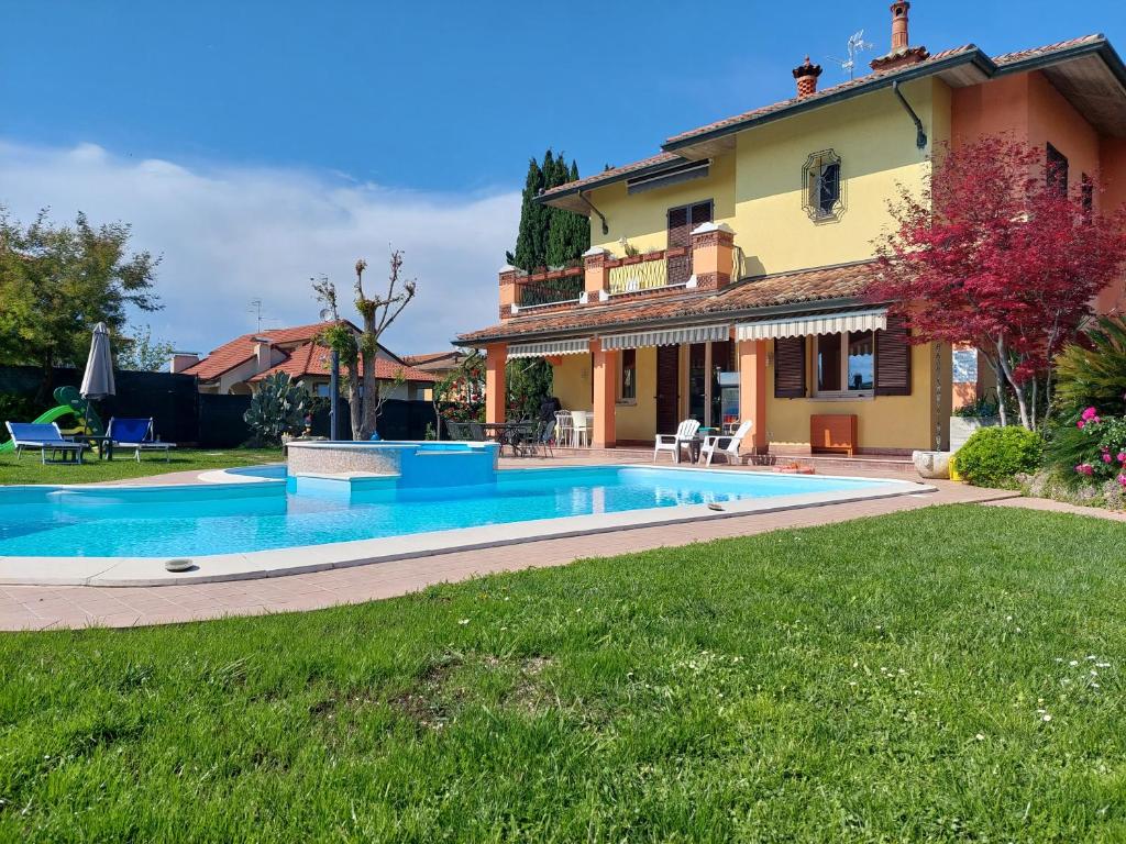 a swimming pool in front of a house at B&B Villa Giulia in Desenzano del Garda