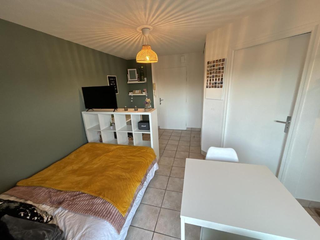 Habitación pequeña con cama y escritorio. en Segur - studio - parking - terrasse - lumineux, en Vannes