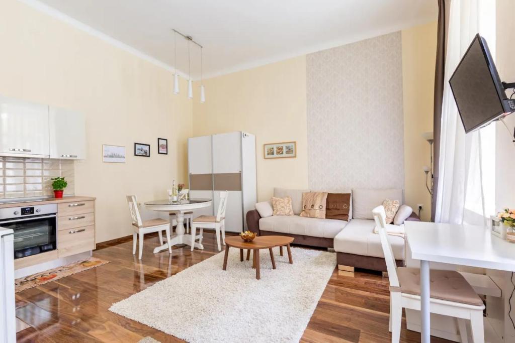 uma cozinha e sala de estar com um sofá e uma mesa em Broadway 32 em Budapeste