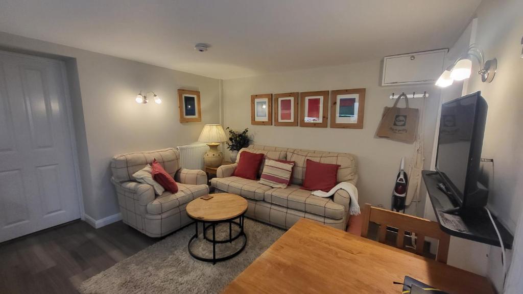 uma sala de estar com dois sofás e uma televisão em The Den, 2 mins Chelt High Street, John Lewis etc em Cheltenham