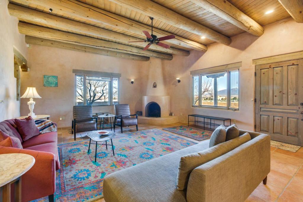 uma sala de estar com um sofá e uma lareira em Taos Adobe Home with Mountain Views and Hot Tub! em Taos
